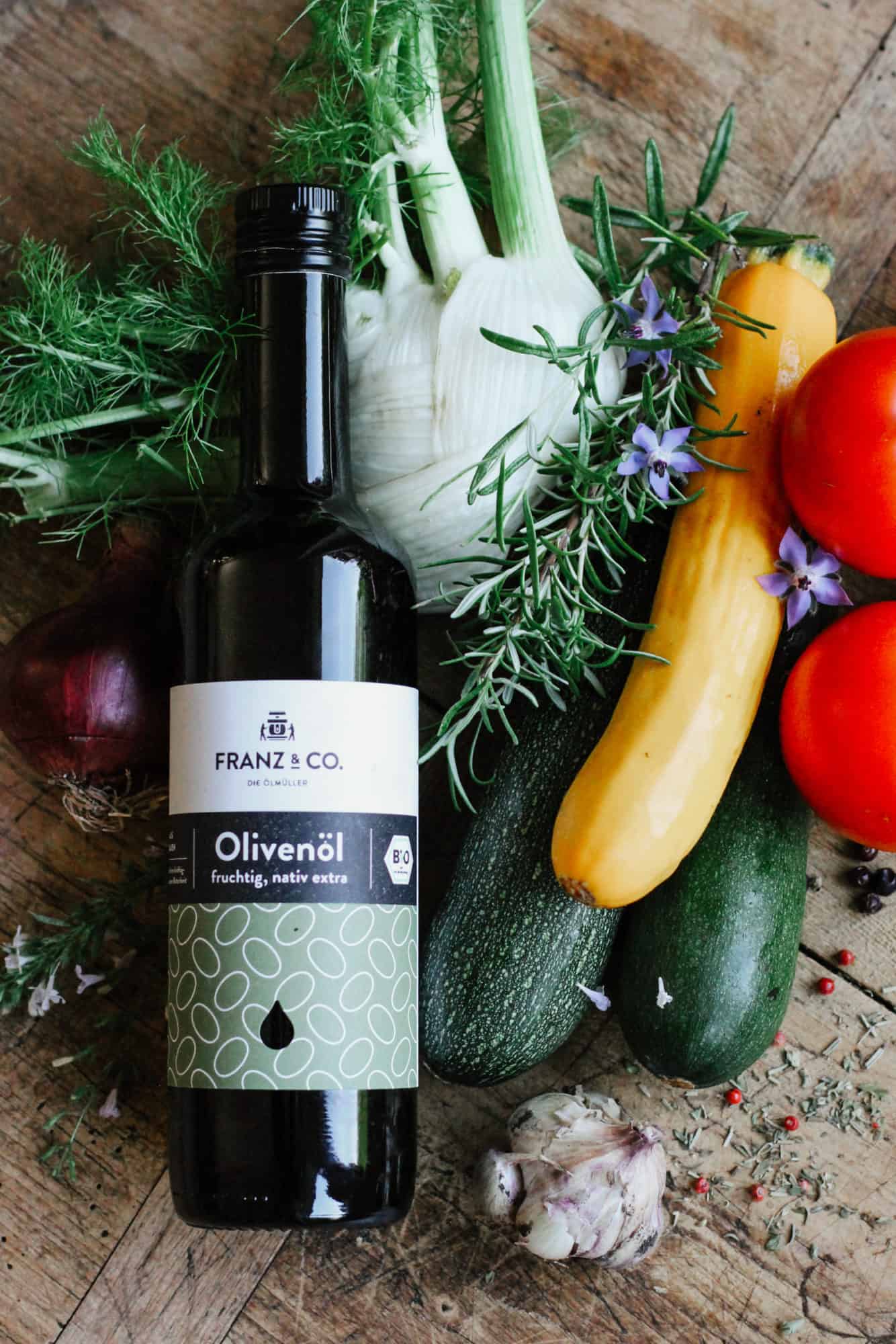 Zutaten für eine klassische mediterrane Antipasti, darunter Fenchel, Zucchini, Tomaten, Knoblauch, Rosmarin und Olivenöl nativ extra