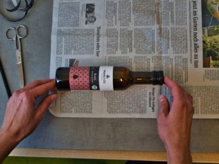 Flaschen mit Zeitungspapier verpacken